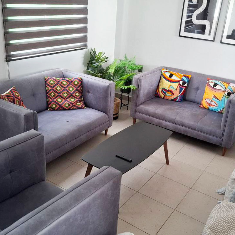 Living room furnished with two sofas, a comfortable chair and art in lower san felipe del agua in oaxaca city