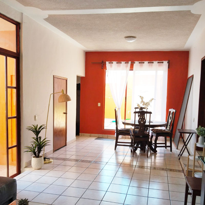 Oaxaca city apartment for rent living room with dining room table and natural light entering through sliding glass door to the back yard